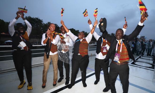 Glada idrottare från Uganda på en båt under OS-invigningen på floden Seine i Paris. Gloria Muzito syns näst längst till vänster.