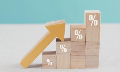 Wooden blocks with percentage sign and arrow up, financial growth, interest rate increase, inflation concept