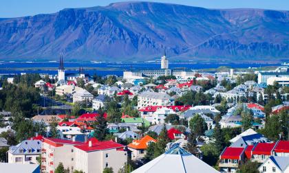 Beautiful summer super wide-angle aerial view of Reykjavik, Iceland with harbor and skyline mountains and scenery beyond the city, seen from the observation tower of hallgrimskirkja church with blue sky in sunny day.