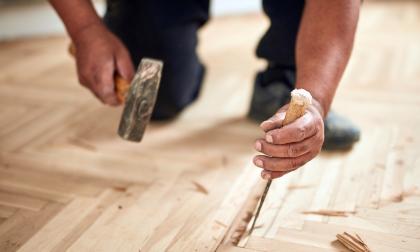 Repairman restoring old parquet hardwood floor.