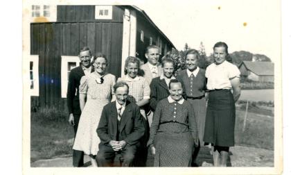 Familjen på Östergårds i Simskäla fotograferad framför granngården Vestergårds för omkring 80 år sedan. Längst till höger Anni Blomqvist (f. Karlsson).
