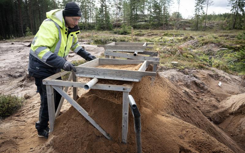 Arkeologen och osteologen Rudolf Gustavsson silar sanden.Foto Daniel Eriksson