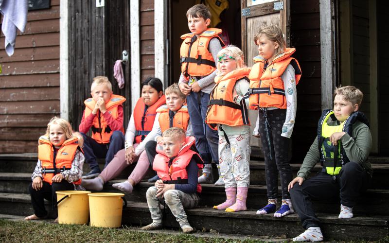 Barnen hjälper simskoleläraren Cajsa Kronström med att ta på sig sin flytväst.