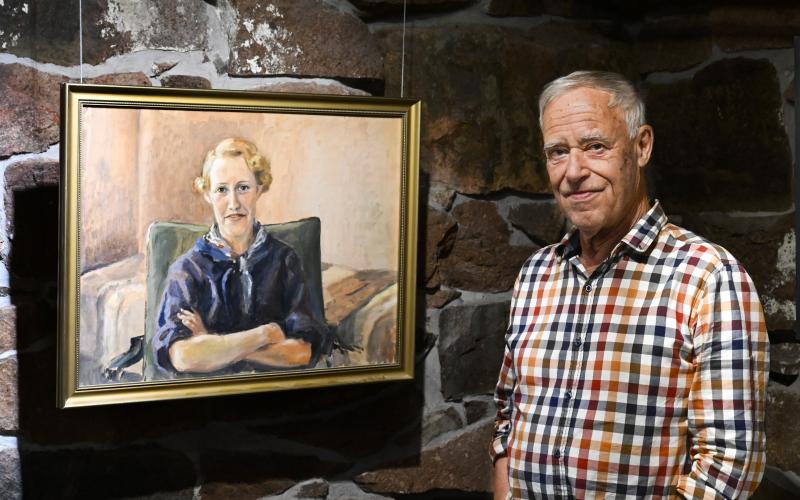 Jan Grönstrand framför ett porträtt pappan målade av hans mamma. Robert Jansson. 