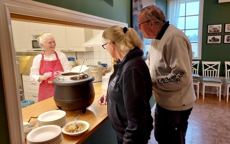  Vid köksluckan står husmor Christina Johansson som med kunnig hand höll i den fina dukningen. Inger och Leif Andersson tar för sig av soppan.@Normal_indrag:<@Fotograf>Maiken Poulsen Englund.