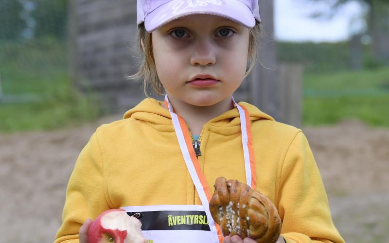 Treåriga Edith Häger kopplar av efter loppet med äppel och bulle.