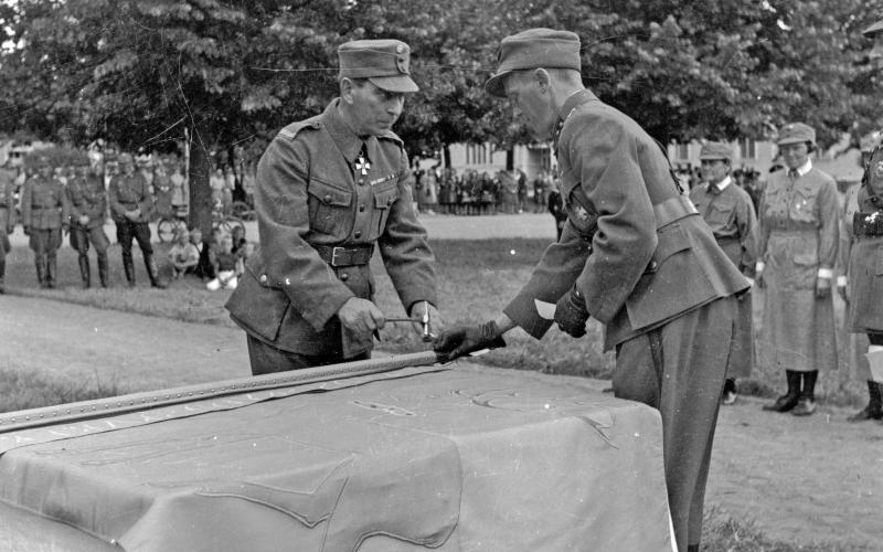 Stadshusparken 13 augusti 1944: landshövding Ruben Österberg slår in den sista nubben i skyddskårsdistriktets nytillverkade fana. <@Fotograf>Elis Fogde