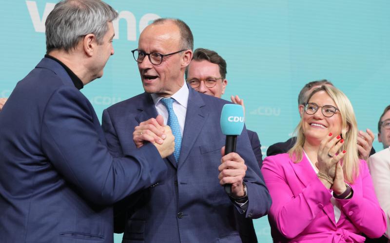 CDU-ledaren Friedrich Merz (mitten) gratuleras till valvinsten av systerpartiet CSU_s Markus Söder och CDU_s ställföreträdande generalsekreterare Christina Stumpp. Genast efter valvinsten visade Merz att han vill ta Europa på en ny väg i säkerhetspolitiken eftersom USA, enligt Merz, inte längre är att lita på.
<@Fotograf>Sandro Halank, Wikimedia Commons